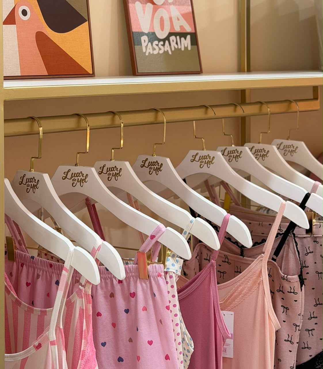 Araras com pijamas LUAR DE MEL® pendurados em cabides personalizados